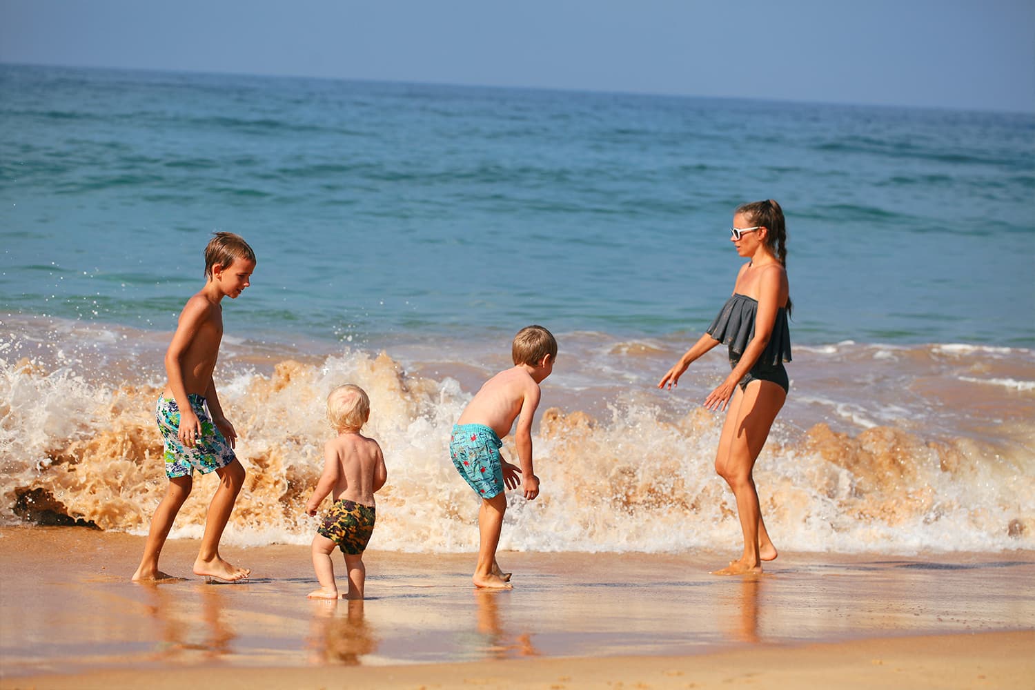 A family enjoying the waves on a Sri Lankan beach