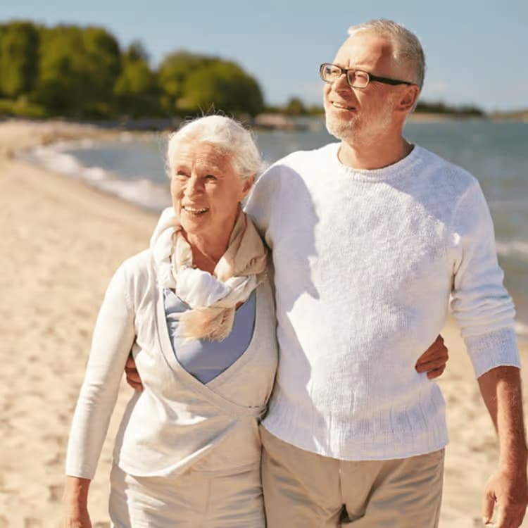 Mature travellers enjoying a relaxed walk beside the beach