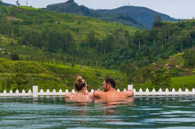 A honeymoon couple relaxing beside Sri Lanka’s green tea country